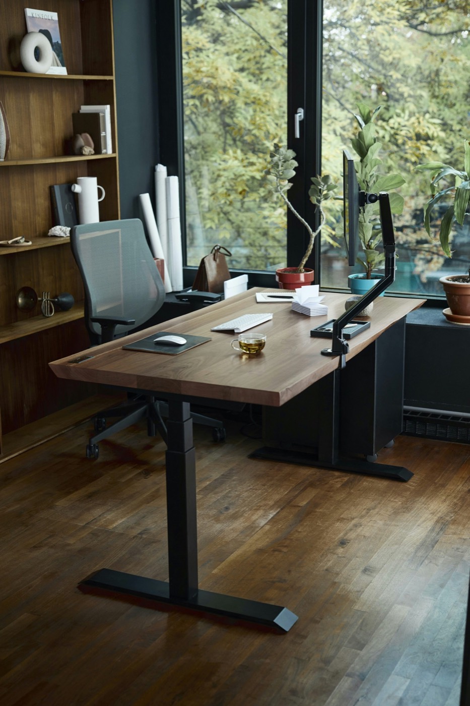 Bureau en bois épuré avec écran et clavier, ambiance calme et lumière naturelle — atelier de création digitale