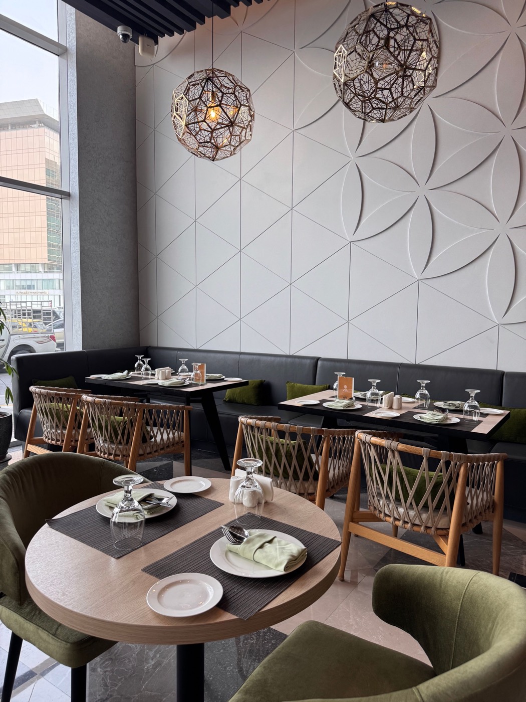 Salle de restaurant contemporaine, tons blancs et noirs, luminaires sculpturaux et mobilier épuré